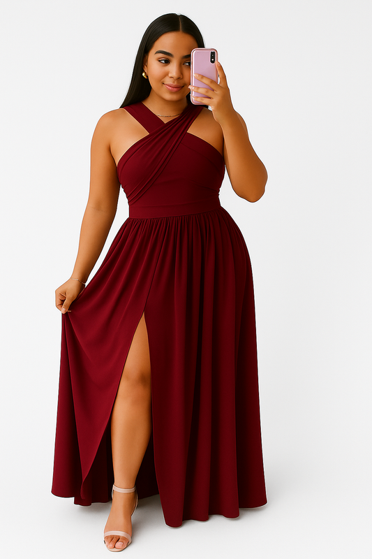 Woman wearing a burgundy SunGlow lightweight summer sleeveless dress with halter neck and flowy skirt with side slit, taking a mirror selfie