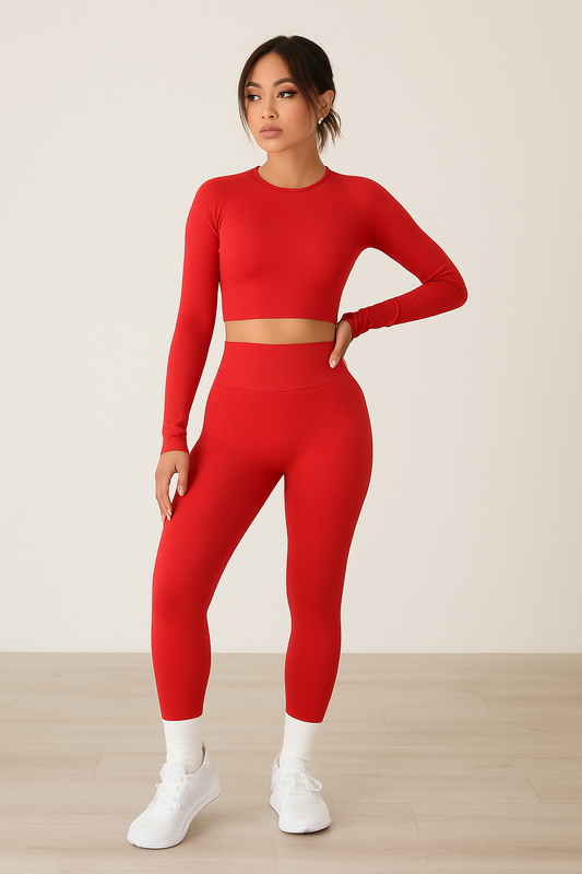 Woman wearing a red fitted long-sleeve crop top and high-waisted leggings fashion exercise yoga suit with white sneakers.