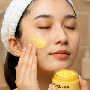 Woman applying turmeric facial cream from skincare set for hydration and glow enhancement.
